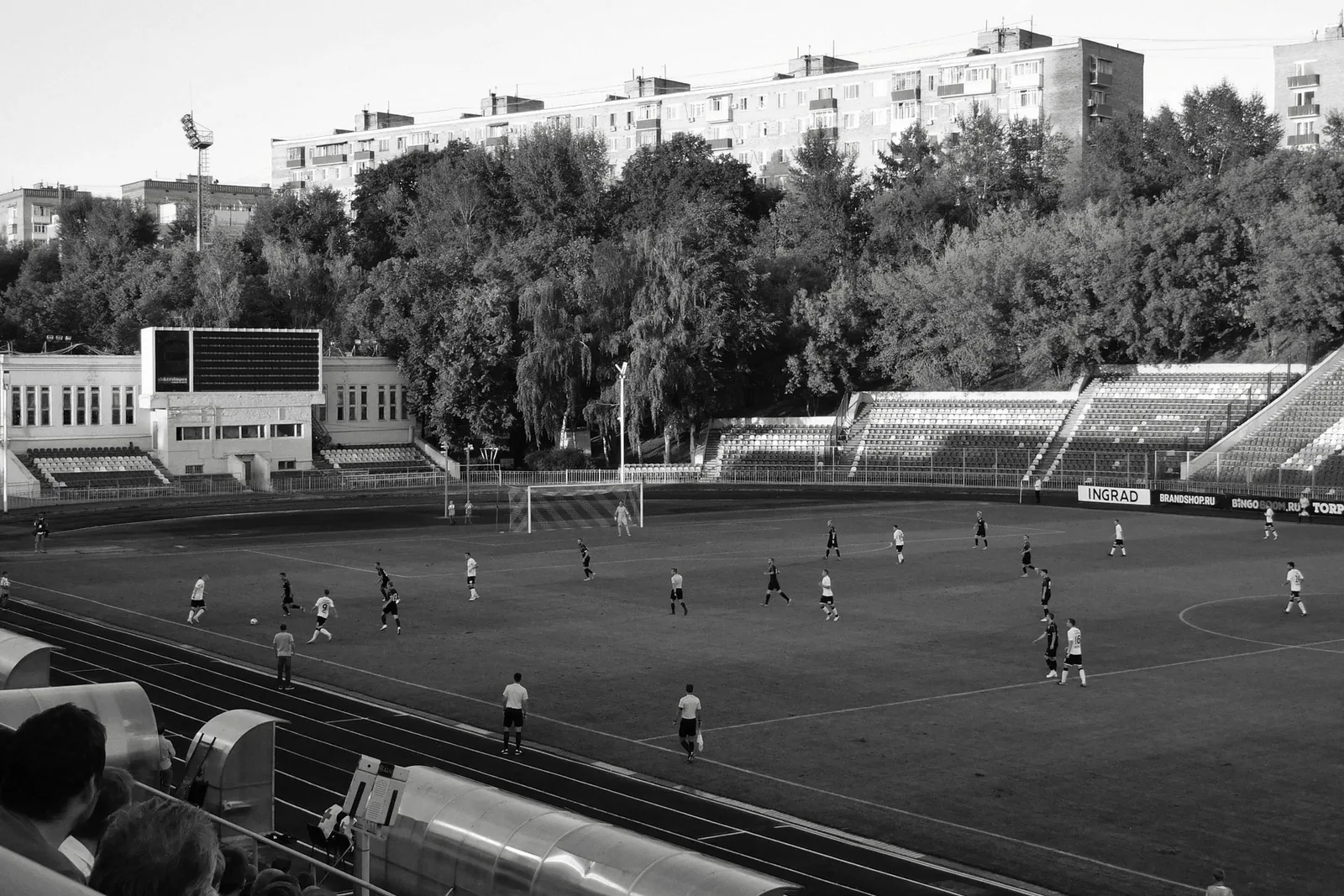 Mustavalkoinen kuva jalkapallo-ottelusta ulkostadionilla
