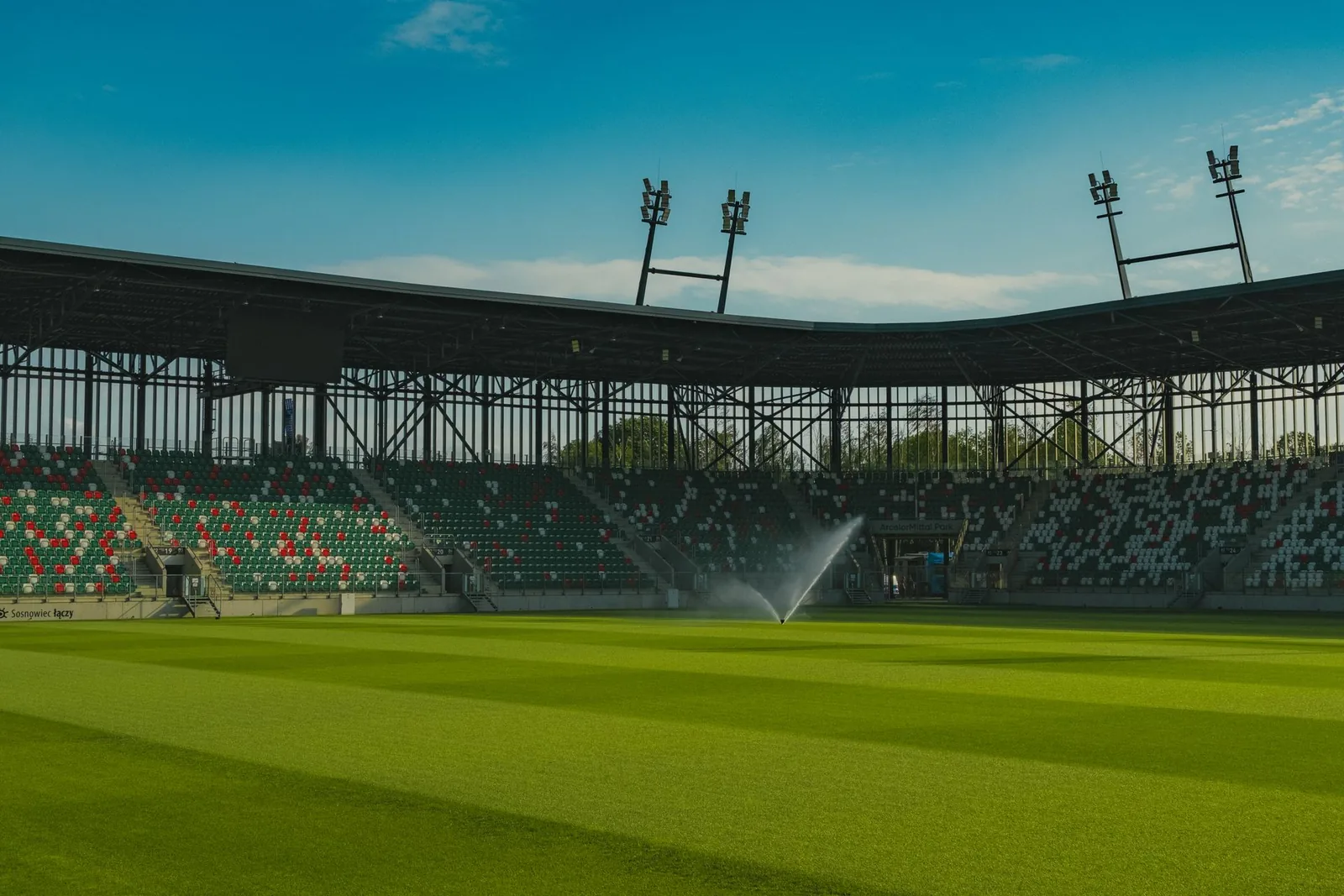 Tyhjä jalkapallostadion kirkkaan sinistä taivasta vasten